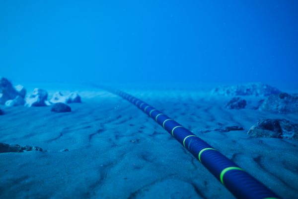 Underwater fiber-optic cable on ocean floor.