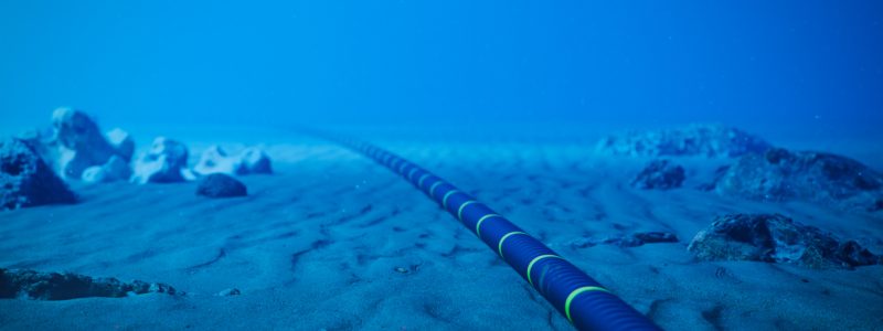 Underwater fiber-optic cable on ocean floor.